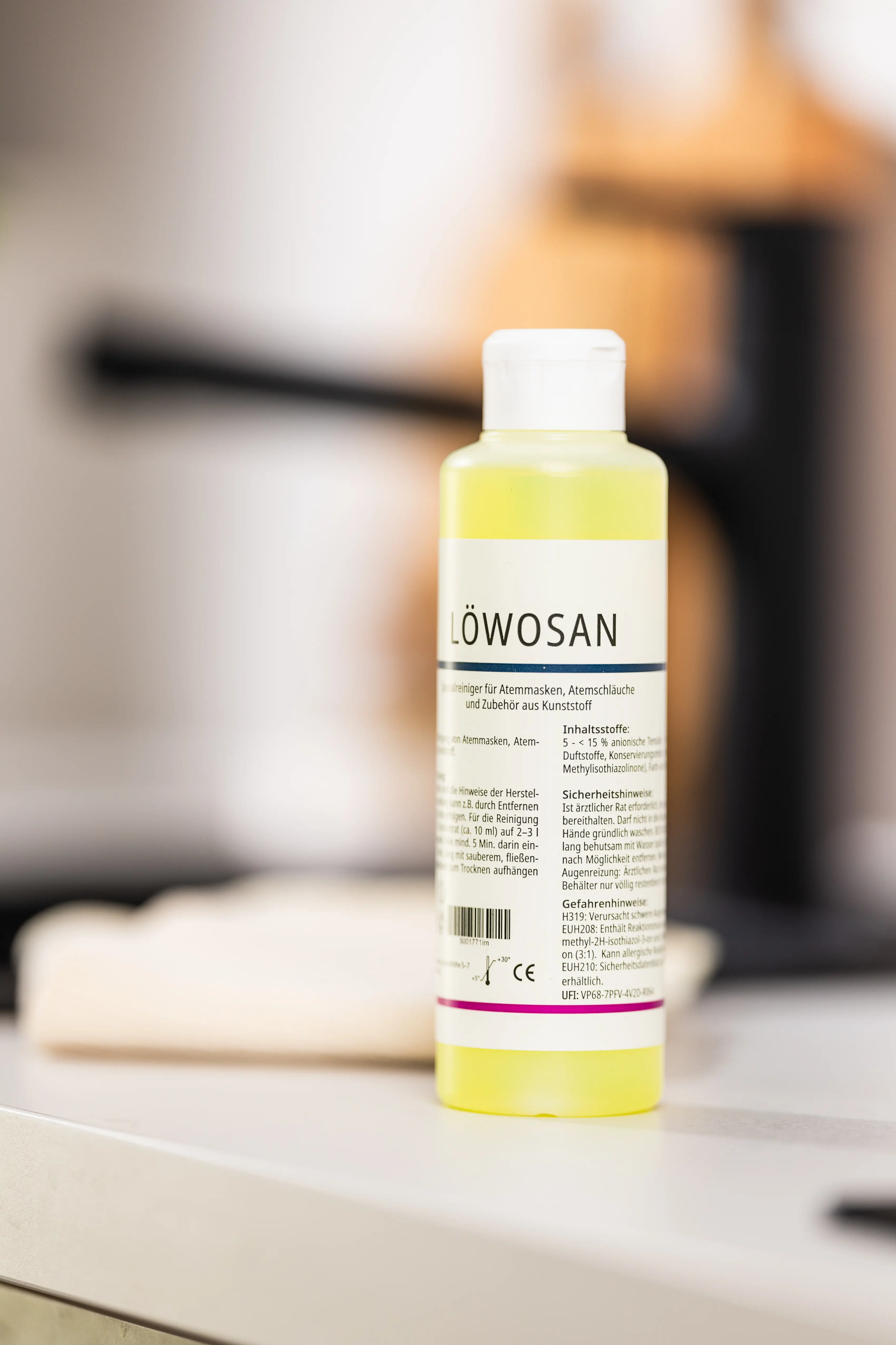 Reinigungsflasche mit dem Etikett "Löwosan" steht auf einer Küchenoberfläche.
