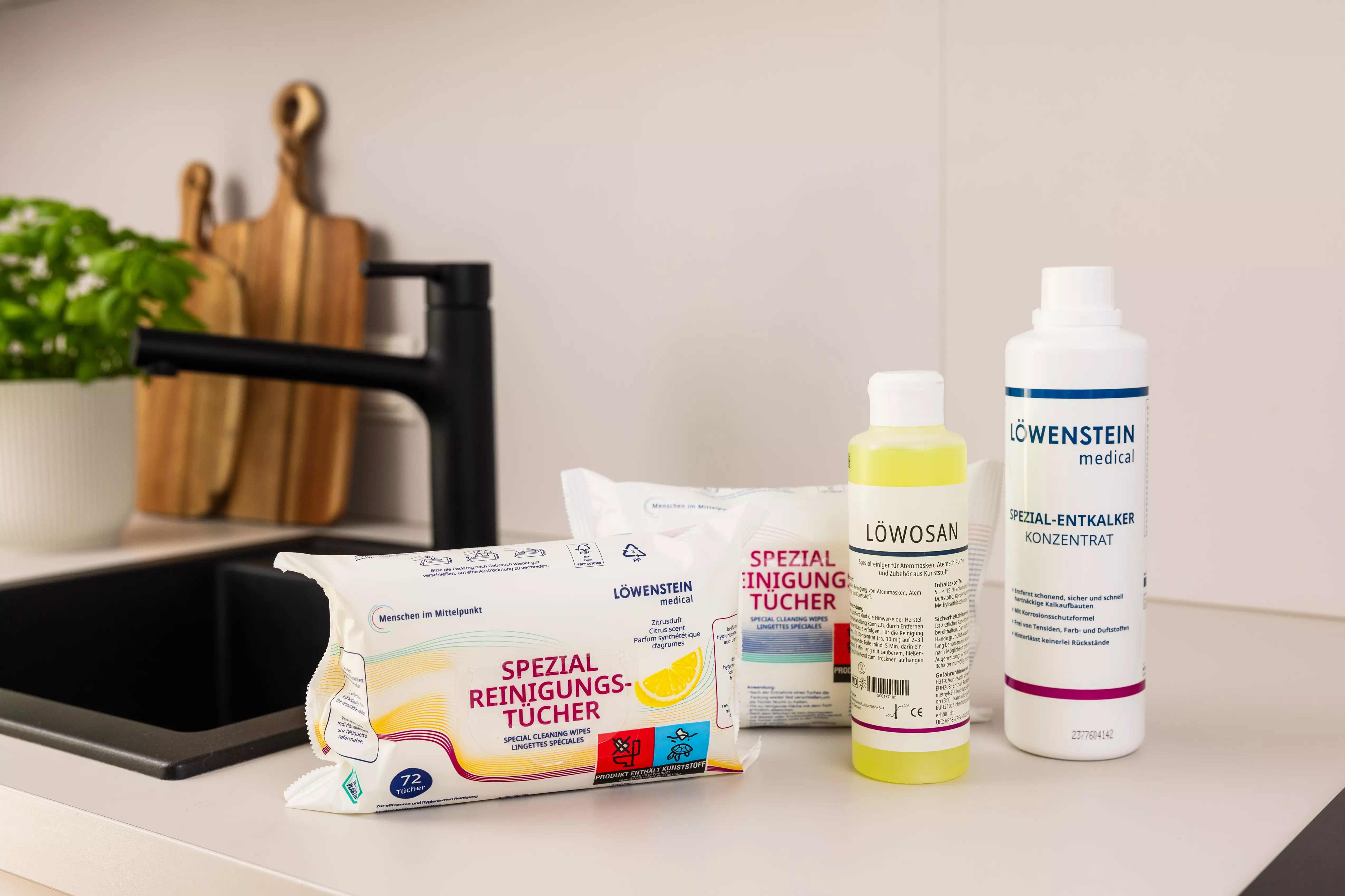 Reinigungspakt 4, bestehend aus Reinigungstücher mit neutralem und Zitronengeruch, stehen zusammen mit dem Entkalker und Löwosan auf einer Küchenoberfläche.